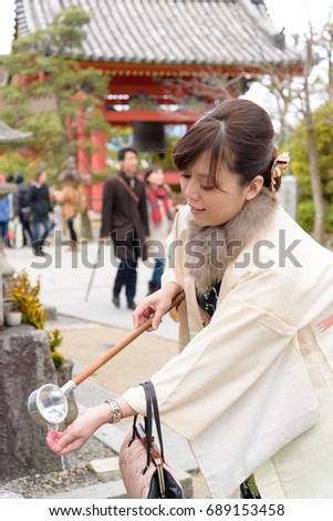 A lady is traveling in Kyoto, Japan.Picture is taken in front of an ordinary temple. Dressed in Japanese traditional clothes called Kimono.Kimono is part of the national costume of Japan.