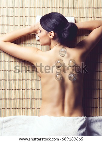 Traditional hot jar cupping massage in spa. Young, beautiful and healthy girl having recreation therapy.
