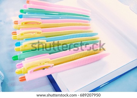Set of colored pens on notebook.