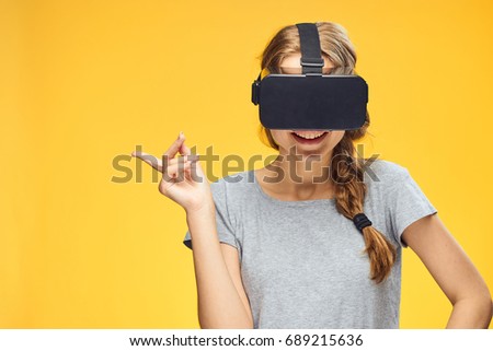 Woman in virtual reality glasses on a yellow background                               
