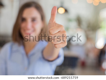 young woman against company background okay sign