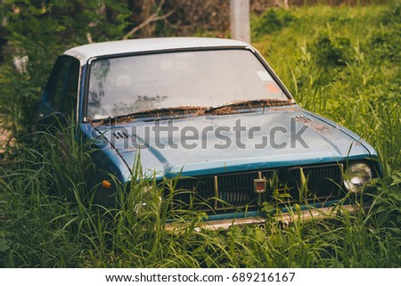 Old car, Discarded old car in overgrown grass on town.