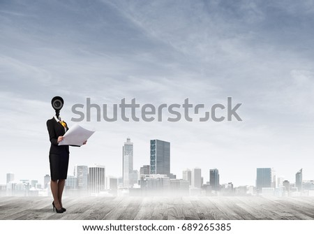 Faceless businesswoman with camera zoom instead of head against cityscape background