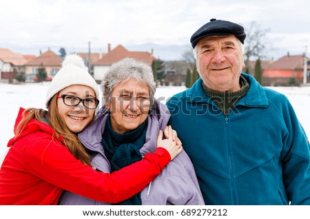 Photo of happy elderly couple and young caregiver