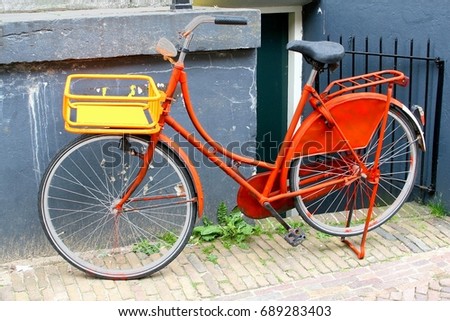 Orange ladies bike in vintage retro style with cargo crate, Amsterdam, Netherlands