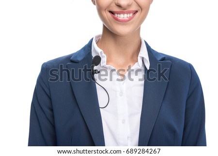 cropped view of smiling female newscaster with tie clip microphone