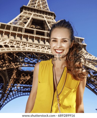 Touristy, without doubt, but yet so fun. Portrait of happy young woman against Eiffel tower in Paris, France