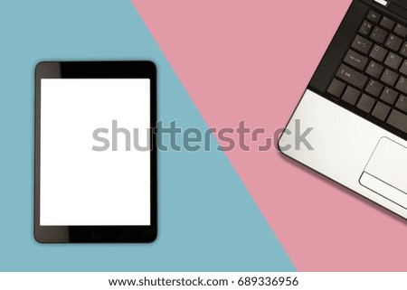 Tablet with blank screen and laptop on pastel color background