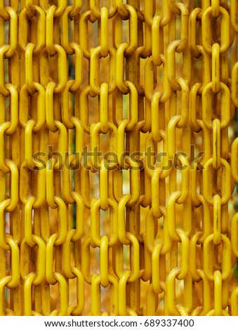 Yellow plastic chains hanged in front of the entrance of butterfly garden to prevent the butterfly from escaping show concepts of linkage, security, and strength