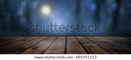 Dark mystical forest with moonlight and rustic wooden floor for a halloween concept