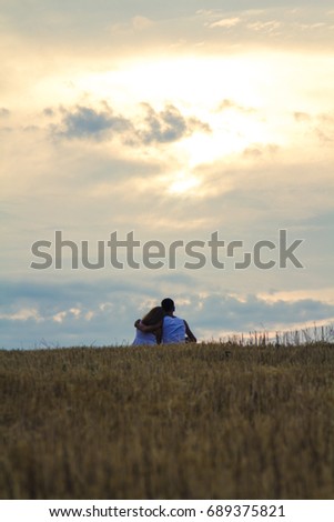 boy and girl in the field at sunset