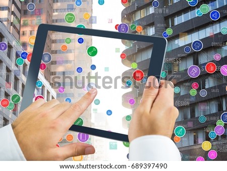 Digital composite of Holding tablet and City with icons colorful floating in sunset