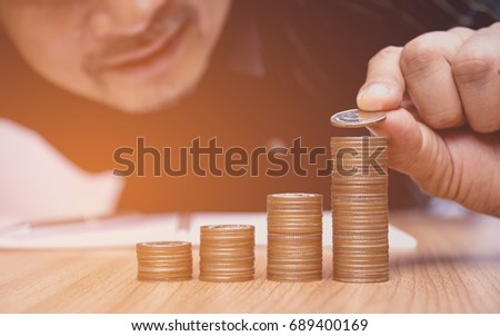 Saving money concept and hand putting money coin stack growing for business