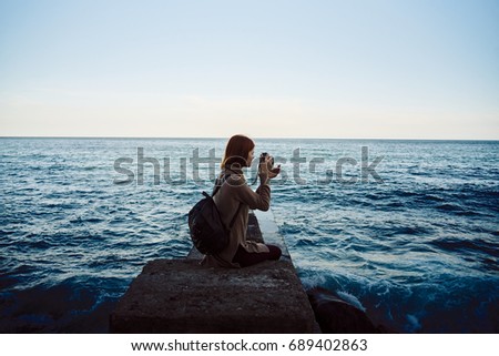 The woman is sitting on the pier at sunset of the day                               