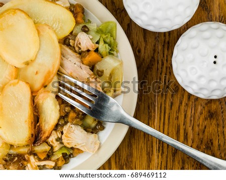 Chicken and Vegetable Hotpot With a Lentil Gravy Against a Dark Oak Wooden Background