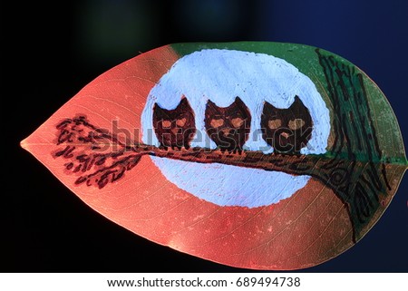 three owls on branch in moonlight  painting on green leaf on red light on black background