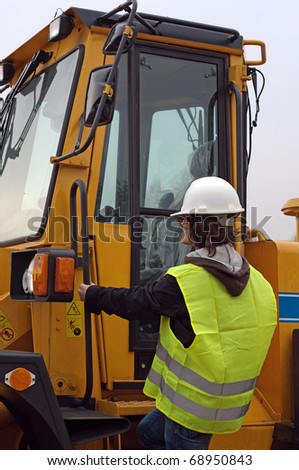 Photo of worker entering excavator.