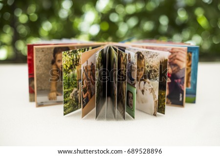 Family photos archive saved in brightly designed photo book; bright summer memories placed in the photobook