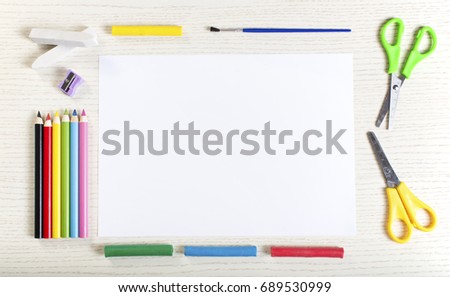 School supplies frame on white paper with empty surface. Plasticine, chalk, sharpener, brush, scissors, crayons and eraser.