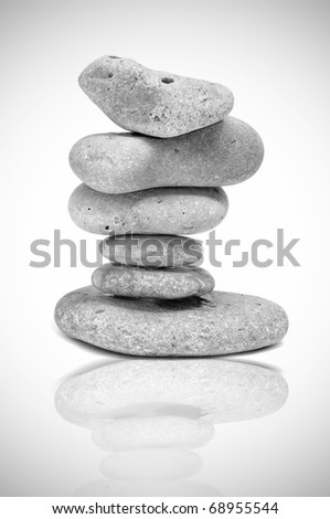 a pile of zen stones reflected on a white background