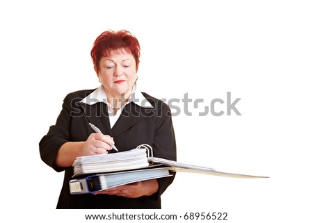 Elderly business woman taking notes in her files