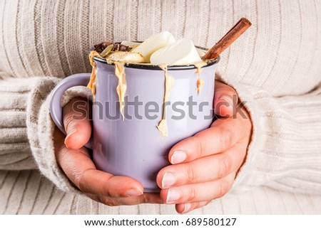 Autumn, winter drinks. Ideas for Christmas, Thanksgiving, Halloween. Girl drink hot spicy pumpkin white chocolate, with marshmallow, cinnamon, anise. With knitted plaid. Copy space, hands in picture
