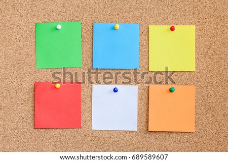 Six color memo reminder cards pinned to cork board. Blank empty copy space square papers background.