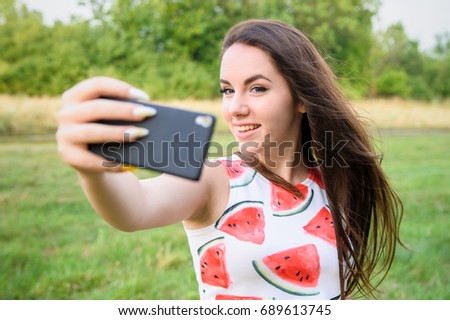 Young beautiful girl doing selfie at sunset