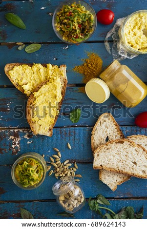 Top view of chicken curry cream served on a bread bruschetta, with ingredients over a blue rusty background