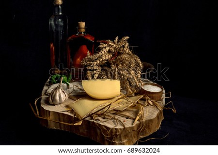 Kraft homemade cheese on the dark background with vegetables with bottles on wood table