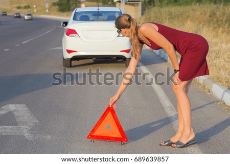The girl puts an emergency stop sign