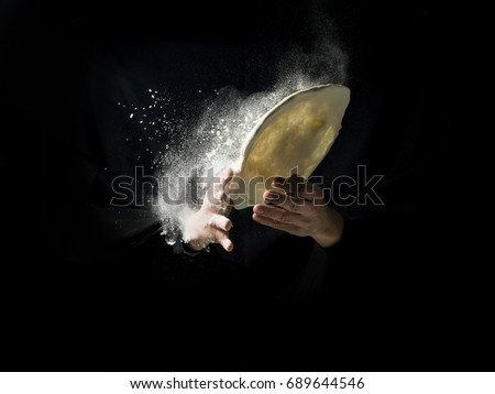 pizza cook's hand with dough and flour