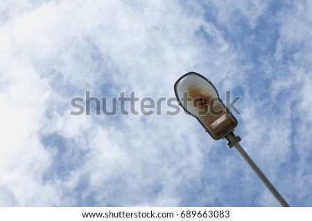Electrical street lamp on cloudy sky background.