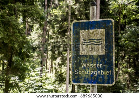 old rusty vintage forgotten german sign in forest translation wasser schutzgebiet means water reserve