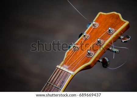 old head acoustic guitar on wooden background. concept for musical instrument background