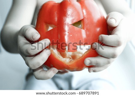 Halloween. Child and pumpkin. Stretches the vegetable forward. Awesome mask. Photo for your design