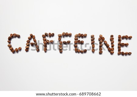 Letter of CAFFEINE arranged with coffee beans on white background with some space for your text Royalty-Free Stock Photo #689708662