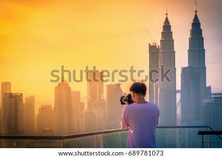 Photography take photo of Kuala lumpur city skyline on the roof top of hotel at sunrise in Malaysia.