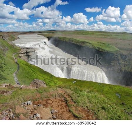 Gullfoss fall on the Iceland with a beautiful blue sky and clouds in background
