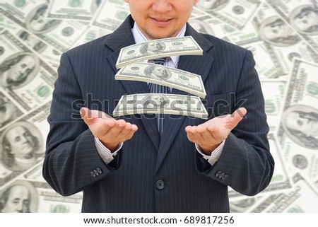Business man catches falling money with money background