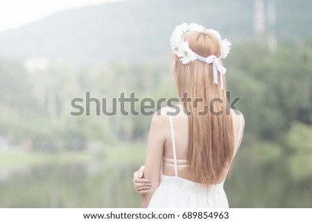 blurred photo Woman sitting with hope on chair,Rear view of a white girl Lonely seats are on the bench in the park,