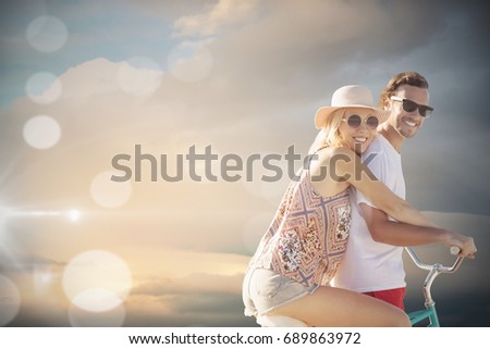 Cute couple on a bike ride digital composite image against cloudy sky during sunset
