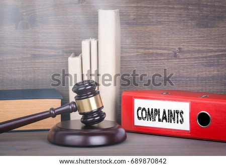 Complaints. Wooden gavel and books in background. Law and justice concept