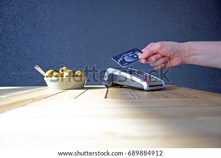 contactless payment card pdq background copy space with hand holding credit card ready to pay at café  olives stock photo, stock, photograph, image, picture 