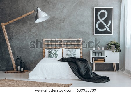 Two white pillows with natural motive on king-size bed with black coverlet