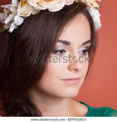 beautiful young woman wearing wreath against red background