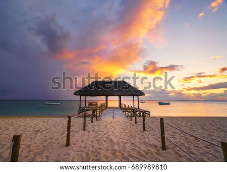 Beautiful sunset in Mauritius Island (flic en flac beach) with Jetty silhouette.