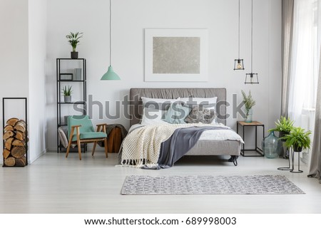 Fresh potted plants in bright room with poster above the bed Royalty-Free Stock Photo #689998003