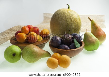 A selection of pears, apricots, plums, and melon