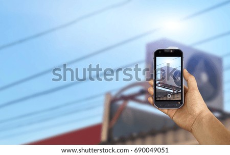 man taking a picture of air conditioner using a smartphone, point of view shot
